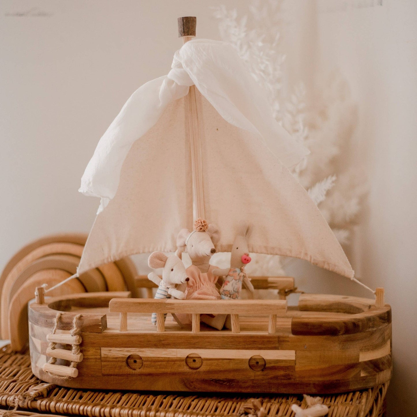 Wooden toy sailboat with mouse dolls on board
