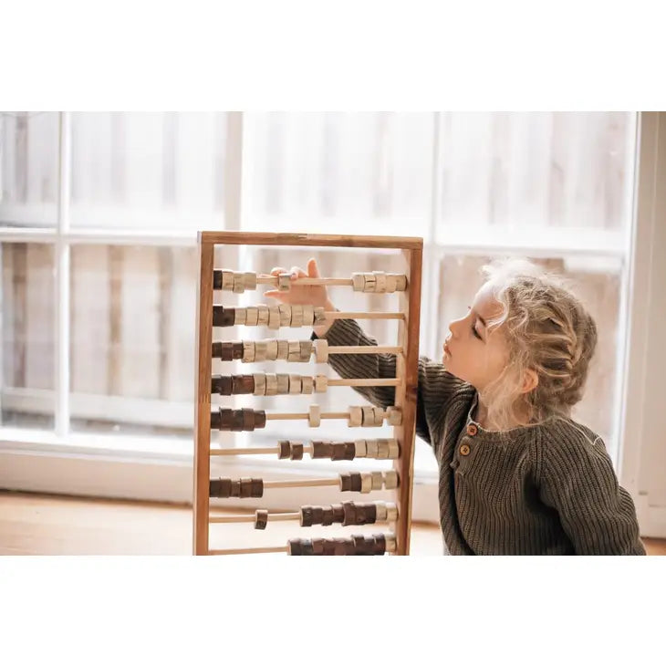 Child playing with wooden abacus toy