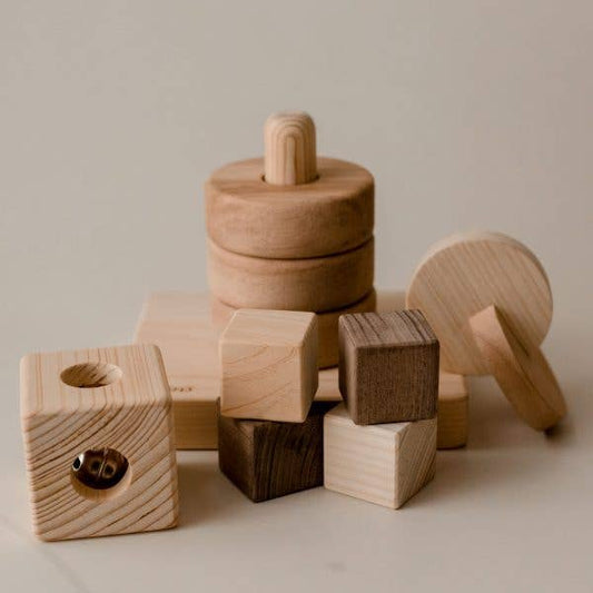Set of assorted small wooden infant toys stacked on one another