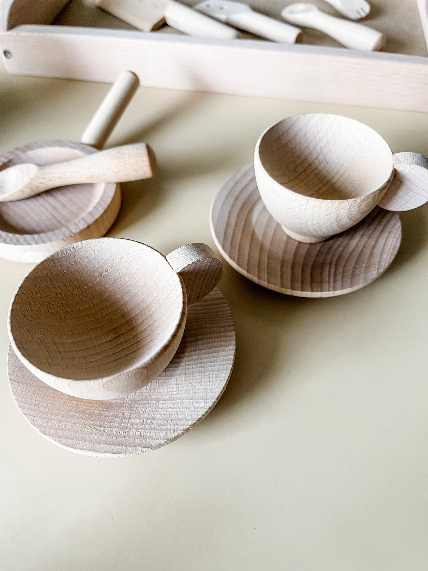 Wooden toy coffee mugs on small plates